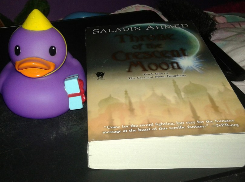 Birthday duck Delilah with the copy of Saladin Ahmed's "Throne of the Crescent Moon" that Vonn got ne